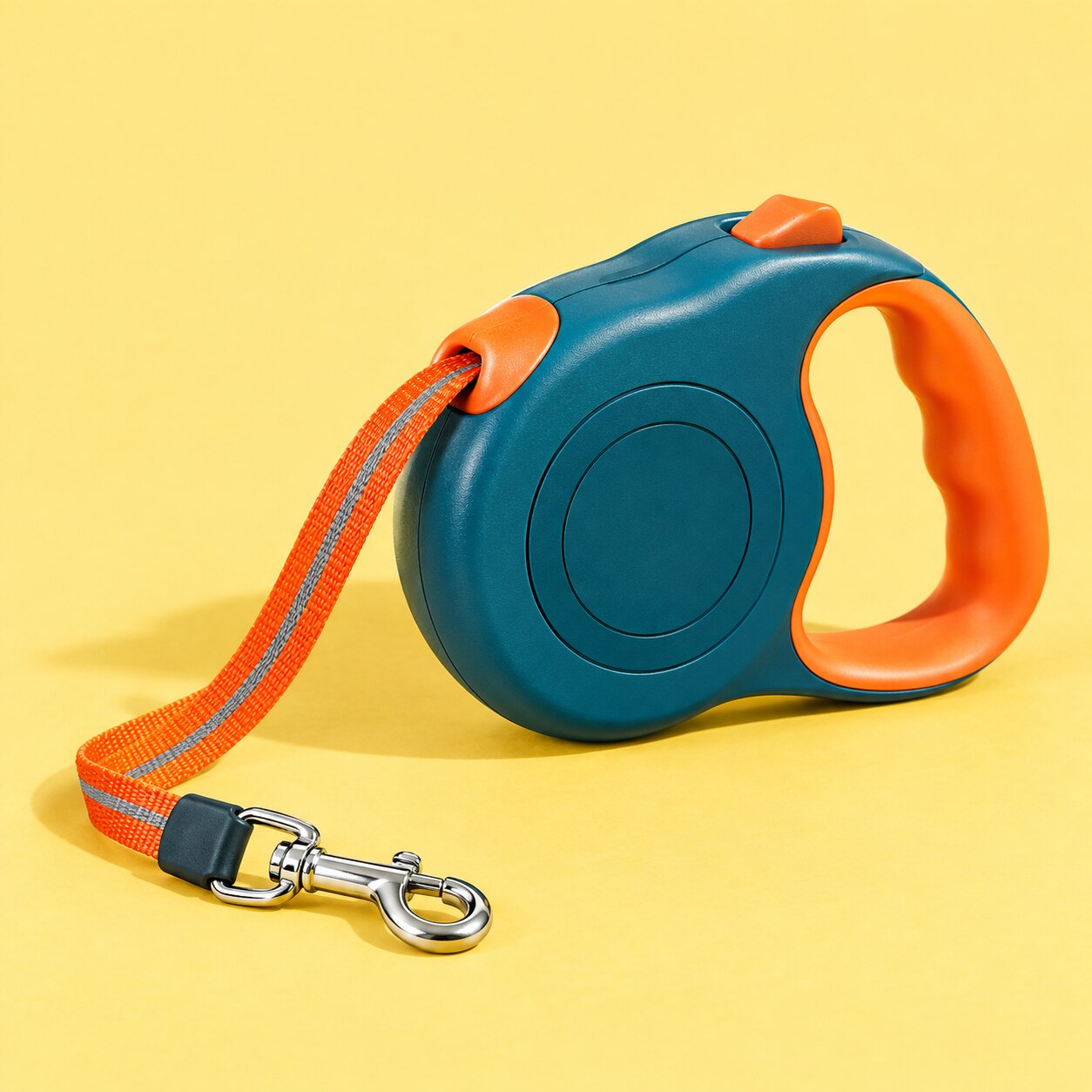 A teal retractable leash with an orange grip on yellow